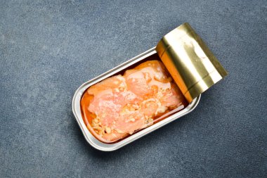 Metal kavanozda konserve somon fileto konservesi. Alüminyum kutularda konserve yiyecekler. Gri beton arka planda.