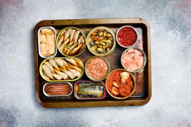 Farklı balık ve deniz ürünleriyle konserve kutuları: balık, havyar, morina ciğeri, lahanalar. Üst görünüm