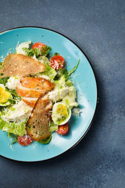Tavuk fileto ve yumurtalı taze sebze salatası. Geleneksel Sezar salatası. Mavi bir tabakta.