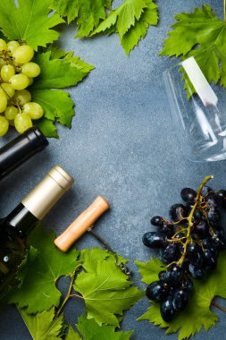 Üzüm ve üzüm yapraklı şarap kadehleri. Gri taştan bir arka planda. Üst görünüm.