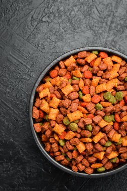 Bir kase evcil hayvan maması. Besleyici, sağlıklı, evcil hayvan maması. Siyah desenli bir arkaplanda.