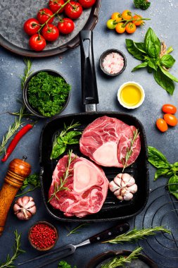 Tavada çiğ Ossobuco bifteği. Gri bir taş masada Ossobuco dana bifteği, baharat, ot, tereyağı ve tuz pişirmek..