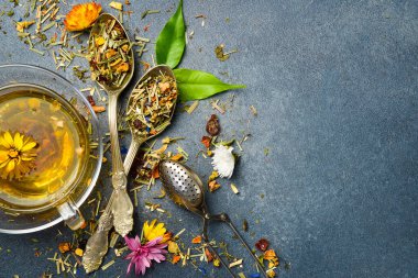 Kaşıkta kurutulmuş bitki çayı. Çiçek çayı yakın. Gri beton arka planda.