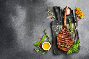 Kemiklerde biftek. Biberiyeli ızgara baltalı biftek ve kesme tahtasında baharat. Üst Manzara. Metin için boş alan.
