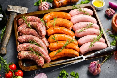 Barbekü için pişirilmemiş et sosisleri ile metal tepsi. Üst Manzara. Karanlık bir arka planda.