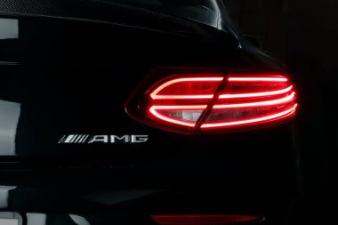 Güzel tasarım, siyah spor araba markası Mercedes Benz c200 AMG Coupe 'nin arka lambasını kontrol ve bakım süresince karanlık garajda bıraktı.