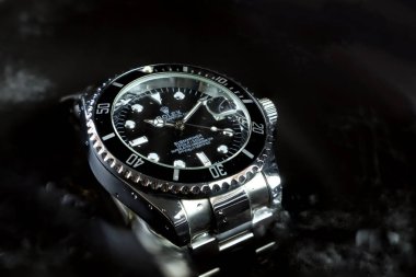 Rolex klasik kol saati seramik model siyah istiridye daimi denizaltı tarihi 39 mm su arka planında saat fuarındaki suya dayanıklı kapasiteyi göstermek için