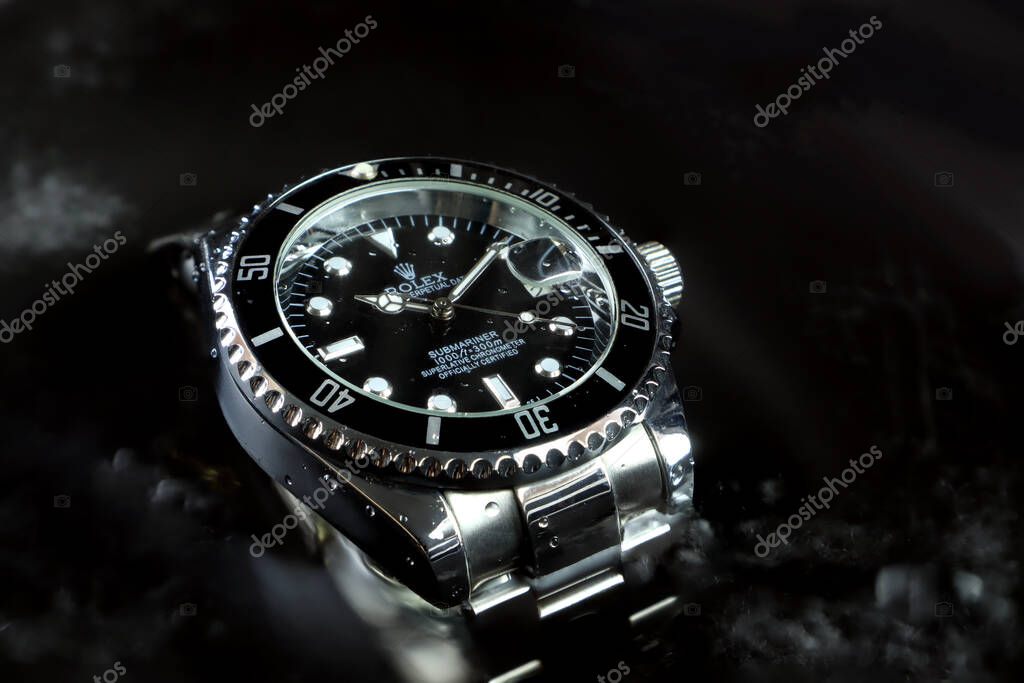 Rolex vintage wristwatch ceramic bezel model black oyster perpetual submariner date 39 mm display in water background to show water resistant capacity in watch expo festival