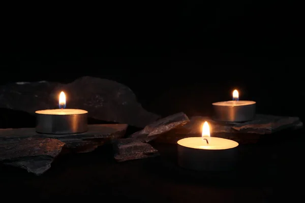 aromatic scented tealight candles are on black table with many stones and background of black wall of house in bed room to creat relax and romantic moment for lovers on Valentine day