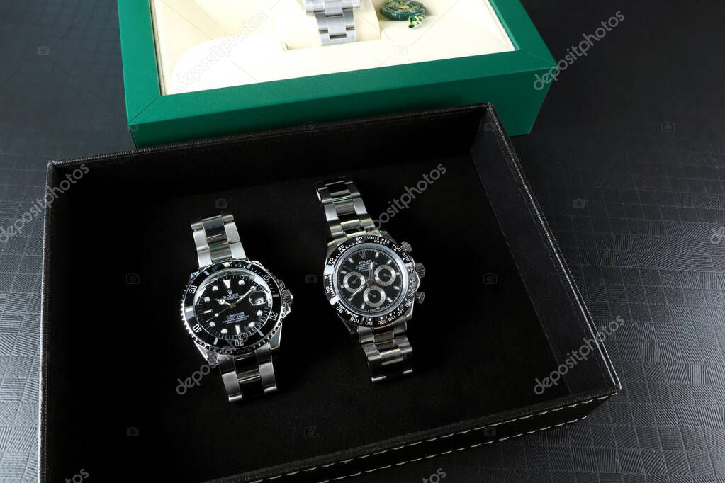 Rolex wristwatch model cosmograph daytona oyster perpetual is on black table with Rolex wristwatch model submariner date black dial with Rolex green box show customers in authorized dealer shop