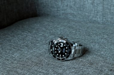 Rolex klasik kol saati seramik model siyah istiridye daimi denizaltı 39 mm 'lik güzel kahverengi koltukta sergileniyor.