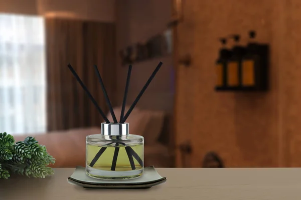 luxury aromatic scent of reed diffuser glass bottle is used as room freshener on nice wooden table in bedroom to creat relax ambient with background of light from window and white bed in morning