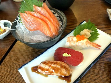 Suşi somon rulosu, Sashimi somonu, Japon restoranında ahşap masada, yeni yıl partisinde ailesiyle yemek yerken.