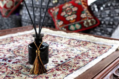 Lüks kokulu kamış yayıcı siyah cam şişe, oturma odasındaki hoş masa spreyi olarak kullanılır. Sevgililer Günü 'nde romantik bir ortam yaratmak ve yastıkların arka planında güzel yastıklar bırakmak için.