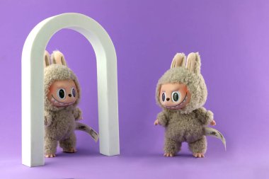 Sanat oyuncakları Labubu anahtarlık koleksiyonu Pop Mart 'ın kör kutusundan toplanabilir sevimli oyuncaklar yeni tanıtım etkinliği labubu macaron bebek sırasında Pop Mart bayrak mağazasının mor raf arka planında sergilenir