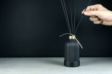 Lüks aroma kokusu yayıcı siyah cam şişe gri taş masa üzerinde romantik yaratmak ve yatak odasındaki ortamı rahatlatmak için mutlu sevgililer günü sabahı siyah çimento duvar arka planıyla.