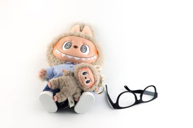 Sanat oyuncakları Labubu benimle takla atıyor Pop Mart 'ın kör kutusundan toplanabilir oyuncak koleksiyonu Pop Mart bayrak mağazasının beyaz raf arka planında yeni çıkan zimomo olay labubu macaron bebeği sırasında sergileniyor.