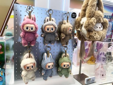 Sanat oyuncakları Labubu anahtarlık koleksiyonu Pop Mart 'ın kör kutusundan toplanabilir sevimli oyuncaklar yeni tanıtım etkinliği labubu macaron bebek sırasında Pop Mart bayrak mağazasının beyaz raf arka planında sergilenir
