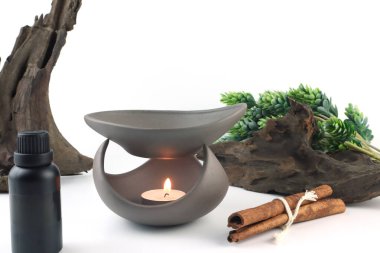 El yapımı kahverengi seramik aroma yağı, beyaz masa üzerinde tarçın, yeşil bitki ve küçük kütük ile süslemek ve rahatlamak için sabah mutlu sevgililer gününde yatak odasındaki spa ortamını oluşturur.