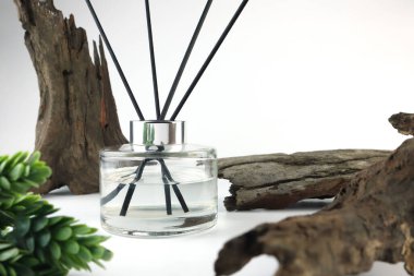 Lüks kokulu kamış kokusu yayıcı cam şişe ahşap masada ve güzel oturma odasındaki eski ahşap arka planda. Bu sayede Noel partisinde odada yayılmış aromalı ortam kokusu yayılabilir.