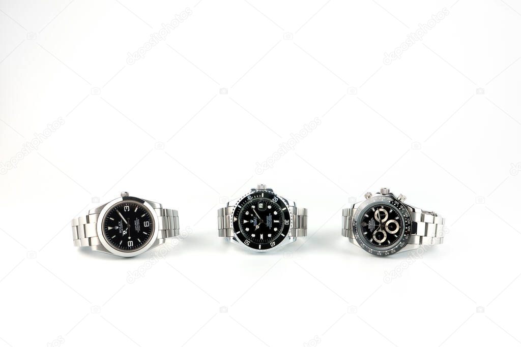 Rolex wristwatch model Daytona , Submariner date and Explorer I stainless steel body isolated on white wooden table in luxury watch shop display for the customers during new release Rolex model event