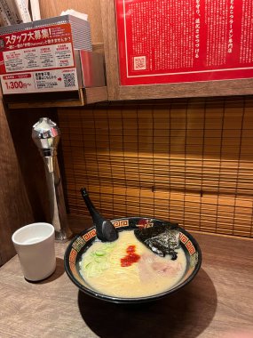 Tokyo Japonya 9 Mayıs 2025, bir kase lezzetli Ichiran ramen, ahşap masa üzerinde bir bardak su ve ahşap perde ve Ichiran Ramen dükkanında menü, ünlü eşsiz tonkotsu çorbası ramen lezzetli