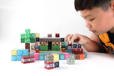 Minecraft manyetik yapı oyuncak blokları, çevrimiçi sanal dünya oyun serisinden beyaz masada birçok çeşit minecraft blokları, magma taşı çim suyu ve sevimli karakterler ile sergilenmektedir.