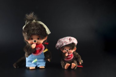 a popular classic doll toy , Monchichi or Monchhichi , Japanese cute monkey fur doll display on white table with white wall background in souvenir tourist shop in Japan