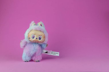 Sanat oyuncakları Labubu anahtarlık koleksiyonu Pop Mart 'ın kör kutusundan toplanabilir sevimli oyuncaklar Pop Mart bayrak mağazasının arka planında enerji labubu macaron bebeğine dönüşürken sergileniyor.