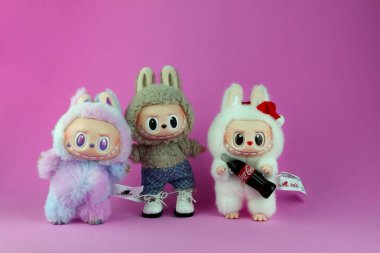 Sanat oyuncakları Labubu anahtarlık koleksiyonu Pop Mart 'ın kör kutusundan toplanabilir sevimli oyuncaklar Pop Mart bayrak mağazasının arka planında enerji labubu macaron bebeğine dönüşürken sergileniyor.