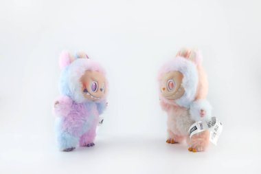 Sanat oyuncakları Labubu anahtarlık koleksiyonu Pop Mart 'ın kör kutusundan toplanabilir sevimli oyuncaklar Pop Mart bayrak mağazasının beyaz raf arka planında enerji labubu macaron bebeğine dönüşürken sergilenir.