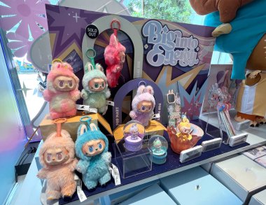 Sanat oyuncakları Labubu anahtarlık koleksiyonu Pop Mart 'ın kör kutusundan toplanabilir sevimli oyuncaklar Pop Mart bayrak mağazasının beyaz raf arka planında satılan labubu macaron bebek etkinliği sırasında sergilenir. 