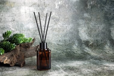 Lüks kokulu kamış aromalı difüzyon şişesi çatlak taş masanın üzerinde romantik bir ortam yaratmak ve sevgililer gününün sabahında gri çatlamış çimento duvar arkasını rahatlatmak için.