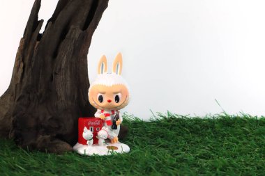 Sanat oyuncakları Labubu anahtarlık koleksiyonu Pop Mart 'ın kör kutusundan toplanabilir sevimli oyuncaklar yeni çıkan Coca Cola labubu macaron bebek albümünde Pop Mart bayrak mağazasının beyaz raf arka planında sergileniyor.