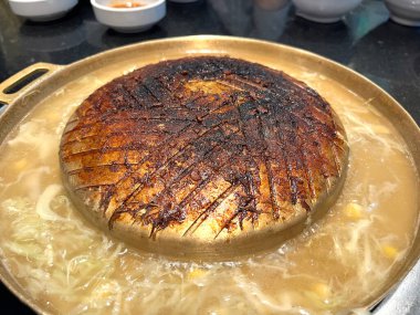 Tayland barbekü ızgarası (Moo Kratha) Kore barbekü sosu ve sıcak tencere stilini birleştirirken altın tavada bol miktarda ızgara ve sebze ve yumurta, yanık barbekü tavası ve ızgara ile çevrili leziz görünüyor.