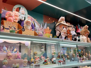 Sanat oyuncakları Labubu anahtarlık koleksiyonu Pop Mart 'ın kör kutusundan toplanabilir sevimli oyuncaklar Pop Mart bayrak mağazasının beyaz raf arka planında satılan labubu macaron bebek etkinliği sırasında sergilenir. 