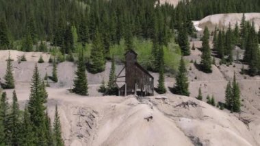 Red Mountain Colorado yakınlarındaki terk edilmiş maden fabrikası. 4K, Kızıl Dağ Colorado yakınlarındaki dik bir arazide terk edilmiş bir değirmeni yakından gören bir insansız hava aracı..