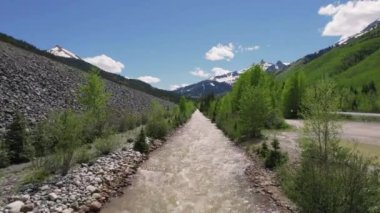 Ouray Colorado yakınlarındaki Kanal 'da güneye uçan 4K, Ouray Colorado yakınlarında sağanak yağış sonrasında hızla akan bir kanalda uçan bir hava aracı görüntüsü sunuyor..