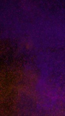 Dikey Orange Mor Parçacık Savaşı 4K Döngüsü dikey oran döngüsünde siyah bir arkaplan etrafında toplanan farklı renkli parçacıklar içerir.