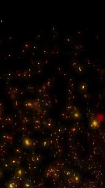 Gece Rüzgarı 4K döngüsünde yükselen dikey közler, dipten ekrana farklı hızlarda parlayan kırmızı, turuncu ve sarı parçacıkları dikey oran döngüsünde siyah bir zemin üzerinde gösterir..