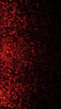 Dikey Kırmızı Parçacık Yağmuru Arkaplan 4K Döngüsü dikey oranda siyah arkaplana çarpan kırmızı parlak parçacıklar içerir.