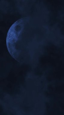 Bir Şimşek Fırtınası 4K döngüsünde dikey Mavi Ay dolunay ve dikey oran döngüsü içinde yuvarlanan bulutlarla dolu karanlık bir gökyüzüne sahiptir..