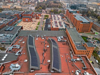 Manufaktura Polonya 'daki Kırmızı Tuğla Endüstriyel Binasının Modern Cam Yapısı Bulutlu Bir Gün' de Kompleksin Park ve Kamu Alanlarına Bakıyor