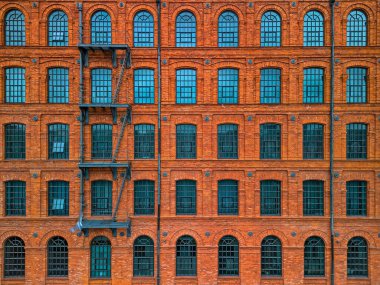 Polonya 'daki Tarihi Kırmızı Tuğla Sanayi Binası Simetrik Cephesi. Çoklu Kıvrımlı Pencereler ve Dış Merdiven