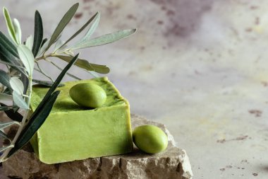 Geleneksel doğal organik zeytin sabunu. Yeşil zeytinli el yapımı sabun barını kapat ve kırsal arka planda yapraklar olsun. Vücut bakımı onaylandı. Seçici odaklanma. Yumuşak bulanık arkaplan.