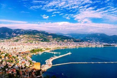 Mediterranean region, Alanya, Turkey. Scenic view of the city, mountains, sea and harbour under cloudy blue sky on sunny day.