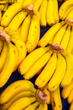Meyve pazarında dikey olarak olgun sarı tatlı muzlar. Muz arka planı. Sağlıklı organik yiyecekler. Kapatın. Seçici odak.