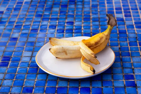 Amarillo Plátano Maduro Medio Pelado Placa Sobre Fondo Mosaico Azulejo —  Fotos de Stock