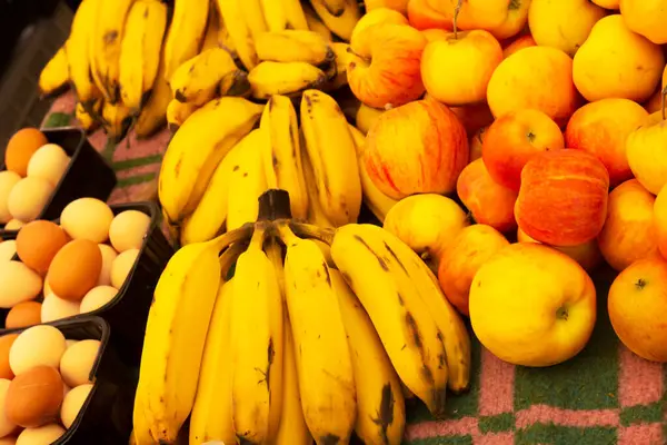 市場カウンターの黄色い甘いバナナ りんごおよび国内の卵を拭いて下さい 農家市場での新鮮な果物や野菜 健康的な有機食品 選択的な焦点 バックグラウンド — ストック写真