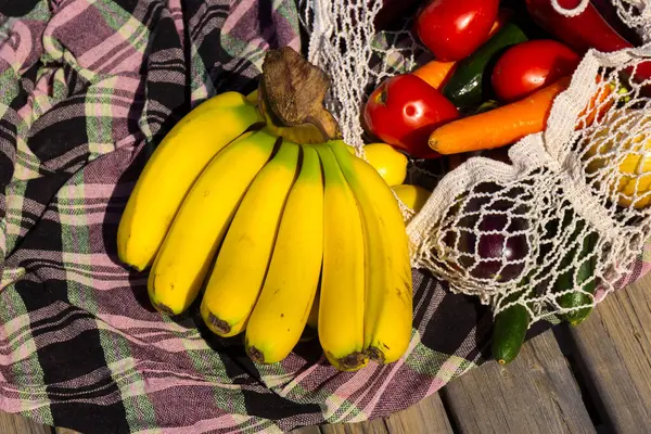 晴れた日のテーブルクロスのアボスカの新鮮な有機果物や野菜のバラエティ バナナ ニンジン トマト ストリングバッグ 健康的な食事コンセプト 選択的な焦点 バックグラウンド — ストック写真